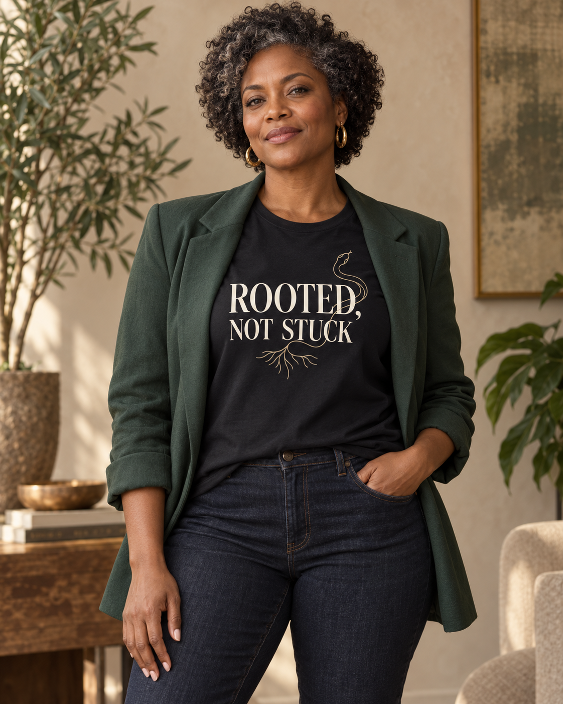Woman wearing the Rooted, Not Stuck black relaxed T-shirt with a forest-green blazer.