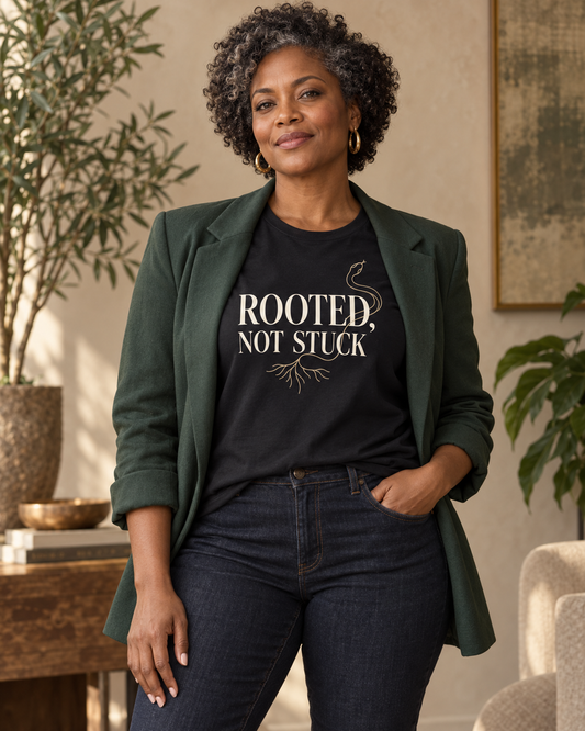 Woman wearing the Rooted, Not Stuck black relaxed T-shirt with a forest-green blazer.